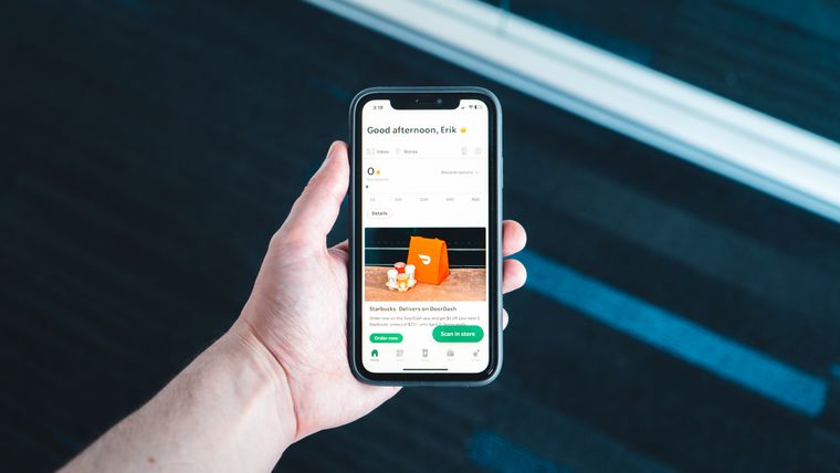 Mano che tiene uno smartphone con una applicazione aperta sullo schermo