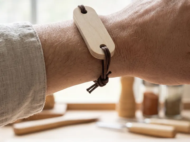 Bracciale in legno con laccio, al polso (immagine generata con AI)