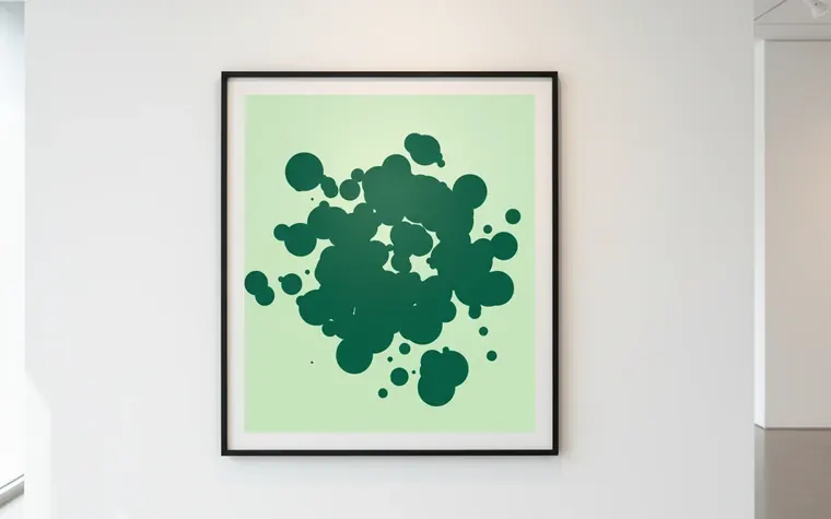 Quadro con un pattern verde a macchie appeso a una parete bianca, fatto con PatternForge (immagine generata con AI)